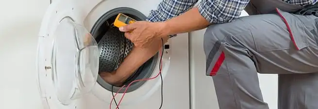 Dryer repair technician inspecting and repairing a clothes dryer in Anaheim, CA
