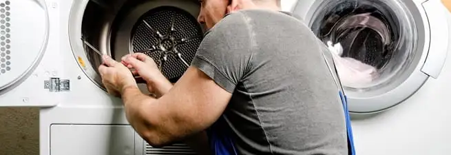 Dryer repair technician fixing a clothes dryer drum in Anaheim, CA