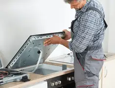 Appliance repair technician installing a built-in cooktop in Anaheim, CA