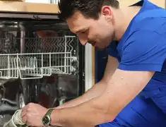 Dishwasher repair technician inspecting and servicing an open dishwasher in Anaheim, CA