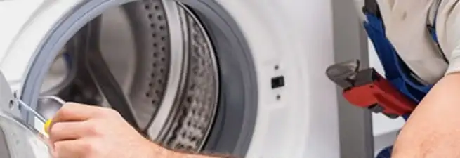 Appliance technician repairing a clothes dryer drum and internal parts in Anaheim, CA