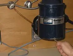 Garbage disposal repair technician tightening the mounting ring under a sink in Anaheim, CA
