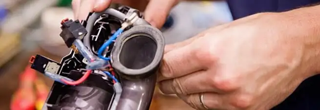 Vacuum repair technician reconnecting wiring and components in Anaheim, CA