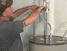 Water heater repair technician tightening supply line connections in Anaheim, CA