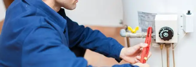 Water heater repair technician adjusting the temperature control and gas valve in Anaheim, CA